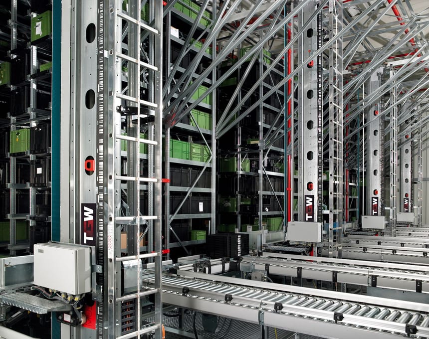 Automated warehouse aisle with high racking and moving inventory systems.